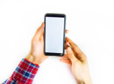 Damalı hippi gömlekli adamların elleri beyaz arka planda bir akıllı telefon tutuyor. Ekran beyaz ve siyah. Eller akıllı telefonu sıkıca kavrasın, çevirsin, çevirsin. Birinci şahıs görüşü. Kontrol et. Boşluğu Kopyala