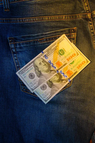 ジーンズのポケットにアメリカの銀行券 100ドルの額の宗派のノートは 一流のズボンのポケットから出て固執する お金はポケットから落ちる フレア効果 異なる角度からの眺め — ストック写真