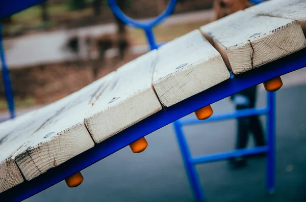 A bridge made of wood sills on a blue metal support. The bridge for children. Bridge of light wooden slats in macro