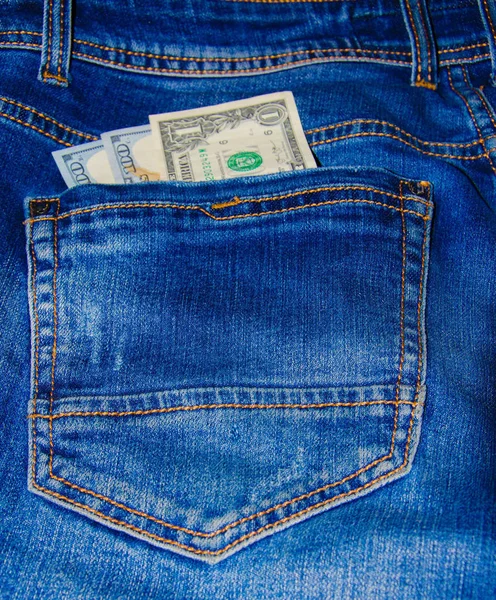 美国钞票在牛仔裤口袋里 一张面值100美元的钞票 从后面伸出来 最前面的裤子口袋 钱从口袋里掉了出来 闪光效果 从不同的角度来看 免版税图库图片