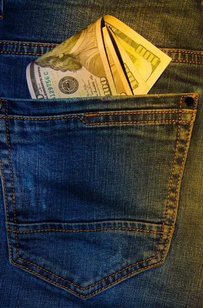 Kot pantolonun cebinde Amerikan banknotları. 100 dolarlık banknotlar halinde bir not, arkadan sarkıyor, en önde gelen pantolon cebi. Para cebimden çıkar. Fişek etkisi. Farklı açılardan görüntüle