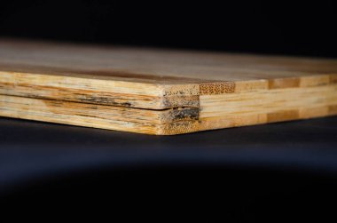 Katı ahşaptan şeritli ahşap bir tahta. Kesme tahtası, ameliyat izleri, kesikler, çizikler. Makro boyutta açı çatlağı