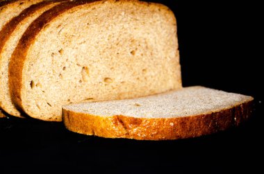 Yaban domuzu, ekmek. Siyah, gri, hardal. Dilimlenmiş, dilimlenmiş, dilimlenmiş, dalgalı arka planda dilimler. Üst manzara, yan manzara. Boşluğu Kopyala