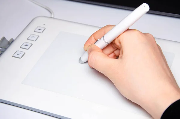 女性の手はグラフィックタブレットで動作します 手はスタイラスペンを持ち ホワイト グラフィック タブレット グラフィックデザイナーの仕事 女の子はノートパソコンに接続されたタブレットで動作します 後ろからの眺め — ストック写真