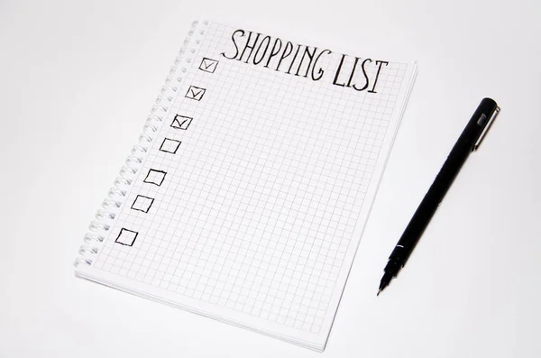 Shopping list. Squared notebook with black pen on a white background. Record ideas, notes, plans, tasks. The list includes bread, milk, bananas. Copy Spase