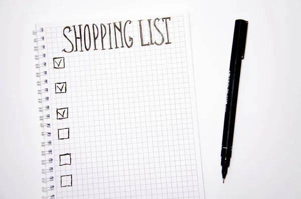 Shopping list. Squared notebook with black pen on a white background. Record ideas, notes, plans, tasks. The list includes bread, milk, bananas. Copy Spase