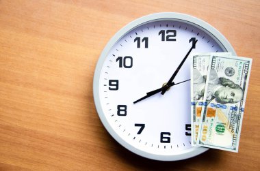 Tahta bir arka planda analog saat ve dolar. Banknotlar saat ve sonraki. Makro. Üst ve yan görünüm. Saat 20: 05, 08: 05. Boşluğu Kopyala