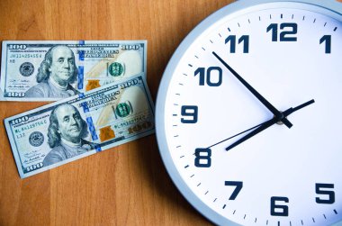 Tahta bir arka planda analog saat ve dolar. Banknotlar saat ve sonraki. Makro. Üst ve yan görünüm. Saat 20: 05, 08: 05. Boşluğu Kopyala