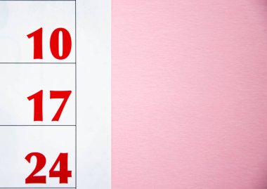 Sarı ve pembe arka planda farklı açılardan Macro takvimi. Takvimdeki siyah ve kırmızı sayılar. Boşluğu Kopyala