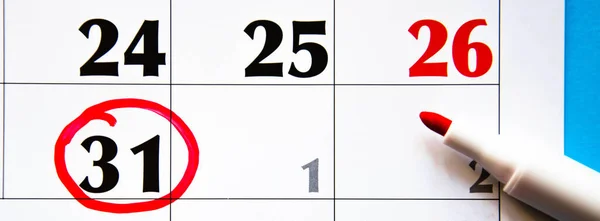 Calendar in close-up on a blue background. Red marker on the calendar. The 31th number in the calendar is circled in red with a marker. Plans, Tasks, Reminders. Copy Space