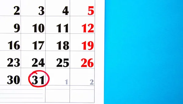 The number 31 in the calendar is circled in red circle on a blue background. A question mark near a number, everything around is dark. Calendar for plans, notes, meetings. Business calendar.