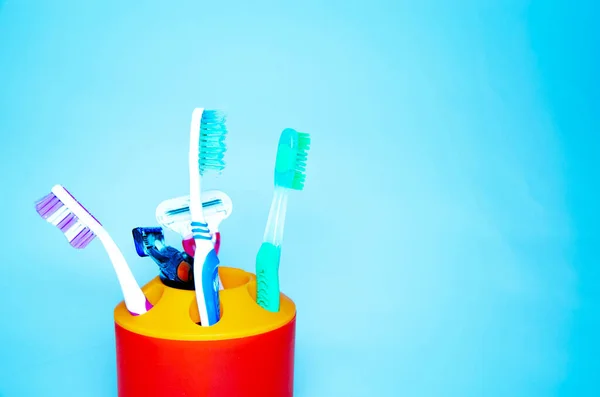 Three Brushes Cleaning Teeth Glass White Orange Blue Background Shaving — Stock Photo, Image