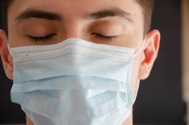 Açık ve kapalı gözlü, tıbbi maskeli bir adam. Coronavirus. Boşluğu Kopyala