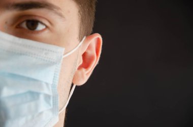 Açık ve kapalı gözlü, tıbbi maskeli bir adam. Coronavirus. Boşluğu Kopyala