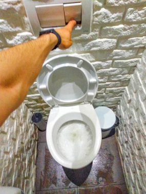 Beyaz tuvaletli giyinme odası. Oda beyaz dekoratif taştan yapılmış, fayanslardan. Tuvalette çiş var. Erkek eli sifonu çeker, birinci şahıs görüşü