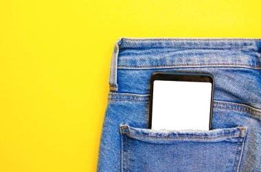 Kotun cebinde beyaz ekran akıllı telefon. Mesaj için akıllı telefon yeri. Sarı arka planda bir cebinde akıllı telefon. Boşluğu Kopyala