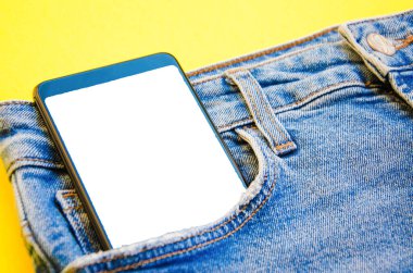 Kotun cebinde beyaz ekran akıllı telefon. Mesaj için akıllı telefon yeri. Sarı arka planda bir cebinde akıllı telefon. Boşluğu Kopyala