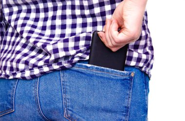 Ekose gömlekli, büyük kalçalı, kot pantolonlu ve arka cebine akıllı telefon sokan genç bir kız. Akıllı telefonu ters çevir ve ileri al
