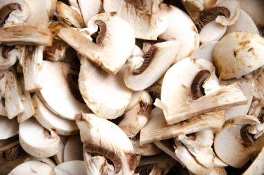 Mantar şampiyonu güvertede doğrandı. Makro mantarlar. El, mantarları bıçakla keser.