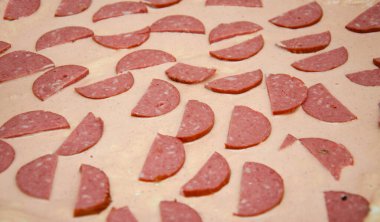 Ev yapımı pizza. Hamurda domates sosu, yarım halka sosis, ızgara mantar, rendelenmiş sert peynir. Çiğ kare pizza.