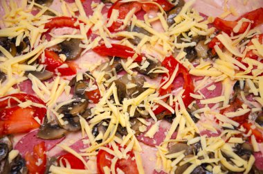 Ev yapımı pizza. Hamurda domates sosu, yarım halka sosis, ızgara mantar, rendelenmiş sert peynir. Çiğ kare pizza.