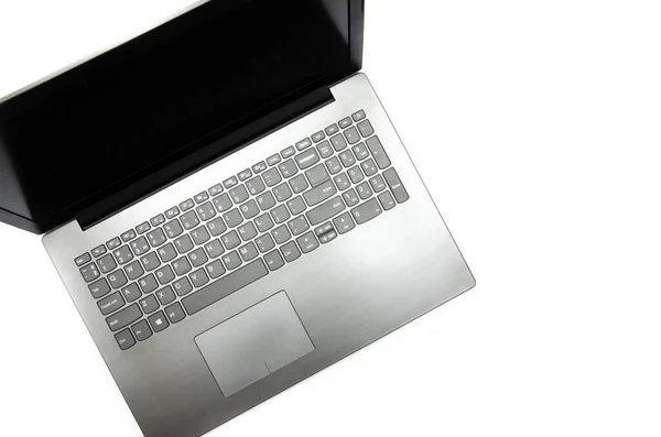 Bilgisayarı beyaz arkaplanda aç. Yukarıdan bak. Dizüstü bilgisayar sol üst köşede yan yatar. Siyah, grafit, gri, koyu renk laptop. Laptop ekranı koyu, kapalı, siyah