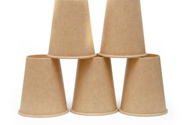 Kahve, çay için kahverengi kağıt bardak, beyaz arka planda çevresel malzemelerden bir içecek. Erkek el makro ve genel plan olarak bir fincan piramidi inşa eder. Metni sol ve sağ tarafa yerleştir.