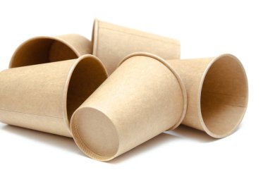 Kahve, çay için kahverengi kağıt bardak, beyaz arka planda çevresel malzemelerden bir içecek. Bir sürü bardak. Gözlükler bir halka şeklinde daire şeklinde yan yatar. Ön ve üst manzara. Makro, boş bardaklar