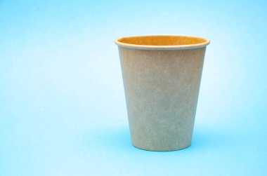 Kahve, çay için kahverengi kağıt bardak, mavi arka plandaki çevresel malzemelerden bir içecek. Sağ tarafta makroda küçük bir fincan var. Ön görünüş ve üst görünüm, alt görünüm. Metni sola yerleştir