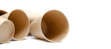 Kahve, çay için kahverengi kağıt bardak, beyaz arka planda çevresel malzemelerden bir içecek. Bir sürü bardak. Gözlükler bir halka şeklinde daire şeklinde yan yatar. Ön ve üst manzara. Makro, boş bardaklar