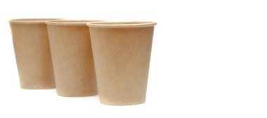 Kahve, çay için kahverengi kağıt bardak, beyaz arka planda çevresel malzemelerden bir içecek. Üç bardak birbiri ardına köşegen ayakta duruyor. Gözlükler perspektife giriyor.