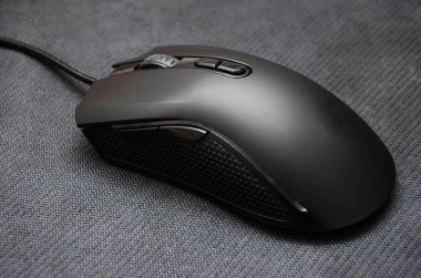 Yan tuşları olan siyah bir oyun faresi ve siyah bir arka planda mat bir son. Farklı açılardan bir fare genel bir plan, makro kenar tuşlar ve ana anahtarlardır. Oyun için örgü, hasıraltı ve fare gibi yüzey