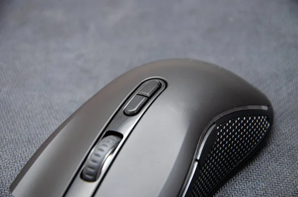 Black gaming mouse with side extra keys and a matte finish on a black background. A mouse from different angles is a general plan and macro side keys and main ones. Surface as a weave, mat and mouse for games