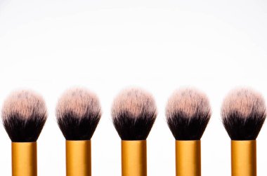 Altın kalemli, siyah kenarlı, kabarık makyaj fırçası. Üst fırçanın üst kısmı üst sırayla aynı ve bir basamak, bir kaide, makyaj fırçalarından bir podyum şeklinde.