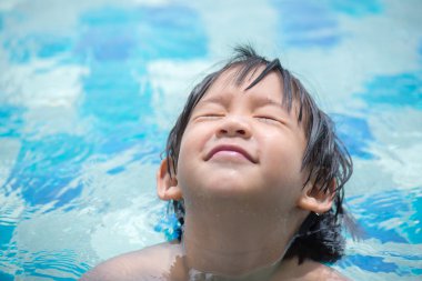 Asyalı çocuk yüzme havuzunda oynayan
