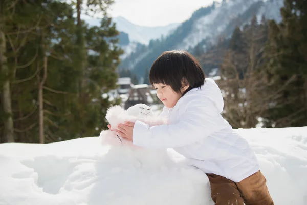 Little boy with snowman — Stock Photo, Image