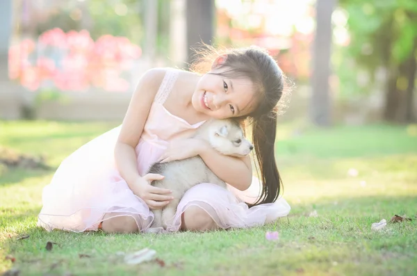 Sian chica jugando con siberiano husky cachorro — Foto de Stock