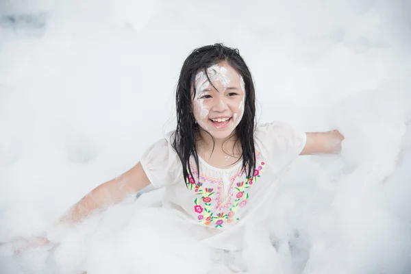 Asiática chica sonriendo en espuma partido — Foto de Stock