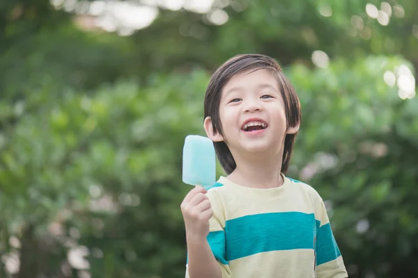 Cute Asian child eating an ice cream outdoors — Stock Photo, Image