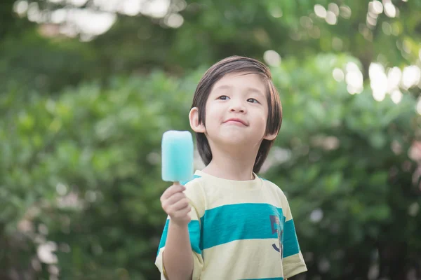 Cute Asian child eating an ice cream outdoors — Stock Photo, Image