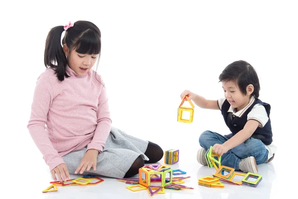 Niños asiáticos jugando con un montón de bloque de plástico imán colorido —  Fotos de Stock