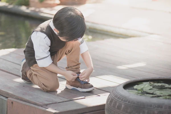 Little asian boy tying his shoes — Stock Photo, Image