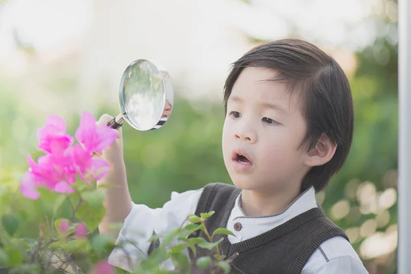 Pojke med förstoringsglas utomhus — Stockfoto