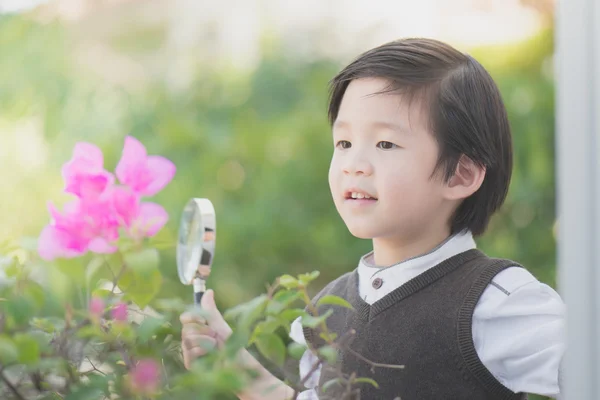 Niño con lupa al aire libre —  Fotos de Stock