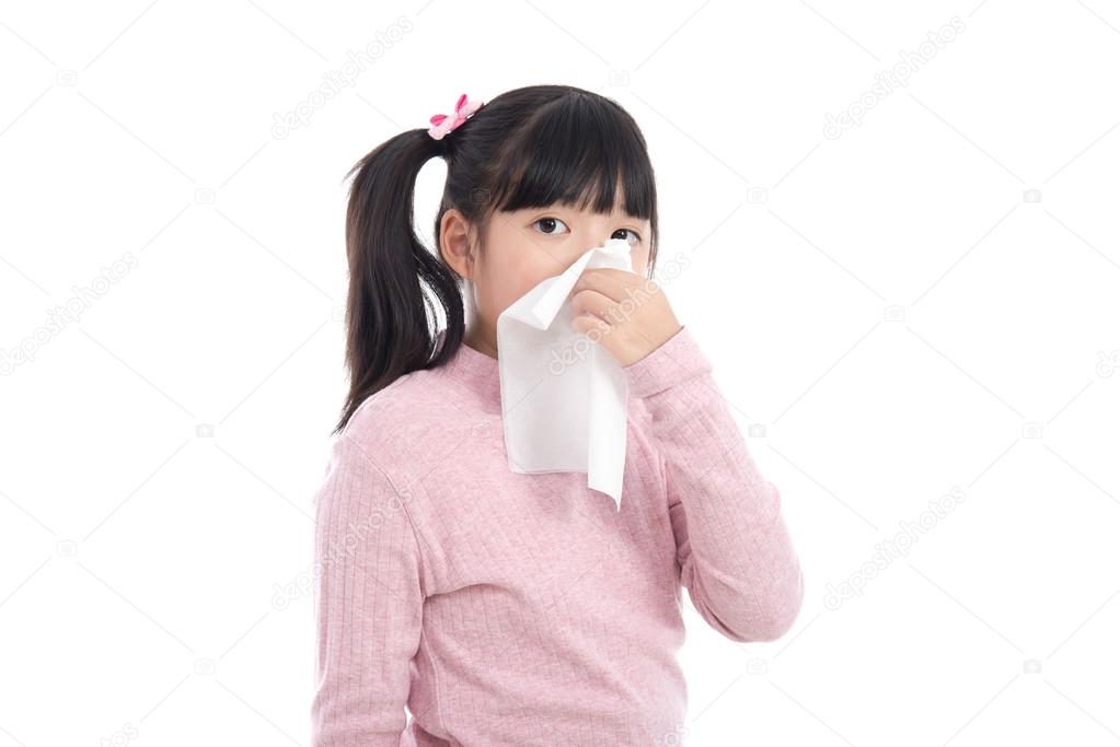 Asian girl blows her nose on white background 