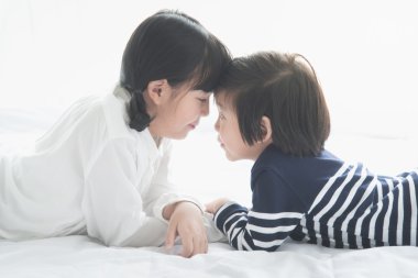 Asya çocuk beyaz yatakta yatarken