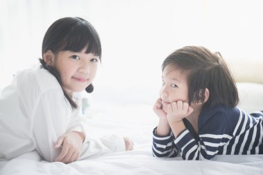 Asya çocuk beyaz yatakta yatarken