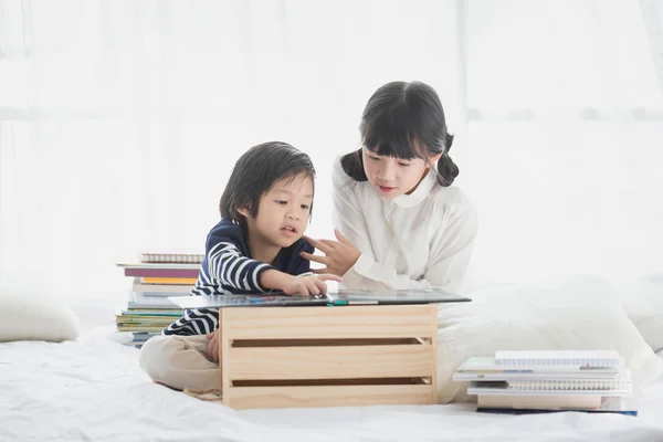 Çocuk beyaz yatak üzerine bir kitap okuma — Stok fotoğraf