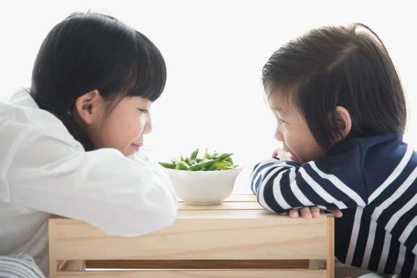 Asiatiska barn äta gröna sojabönor — Stockfoto