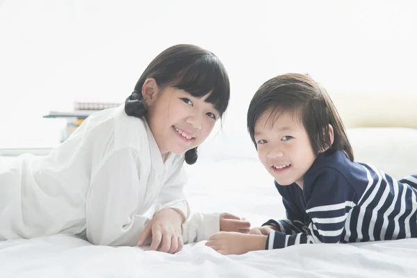 Asiático niños acostado en blanco cama —  Fotos de Stock